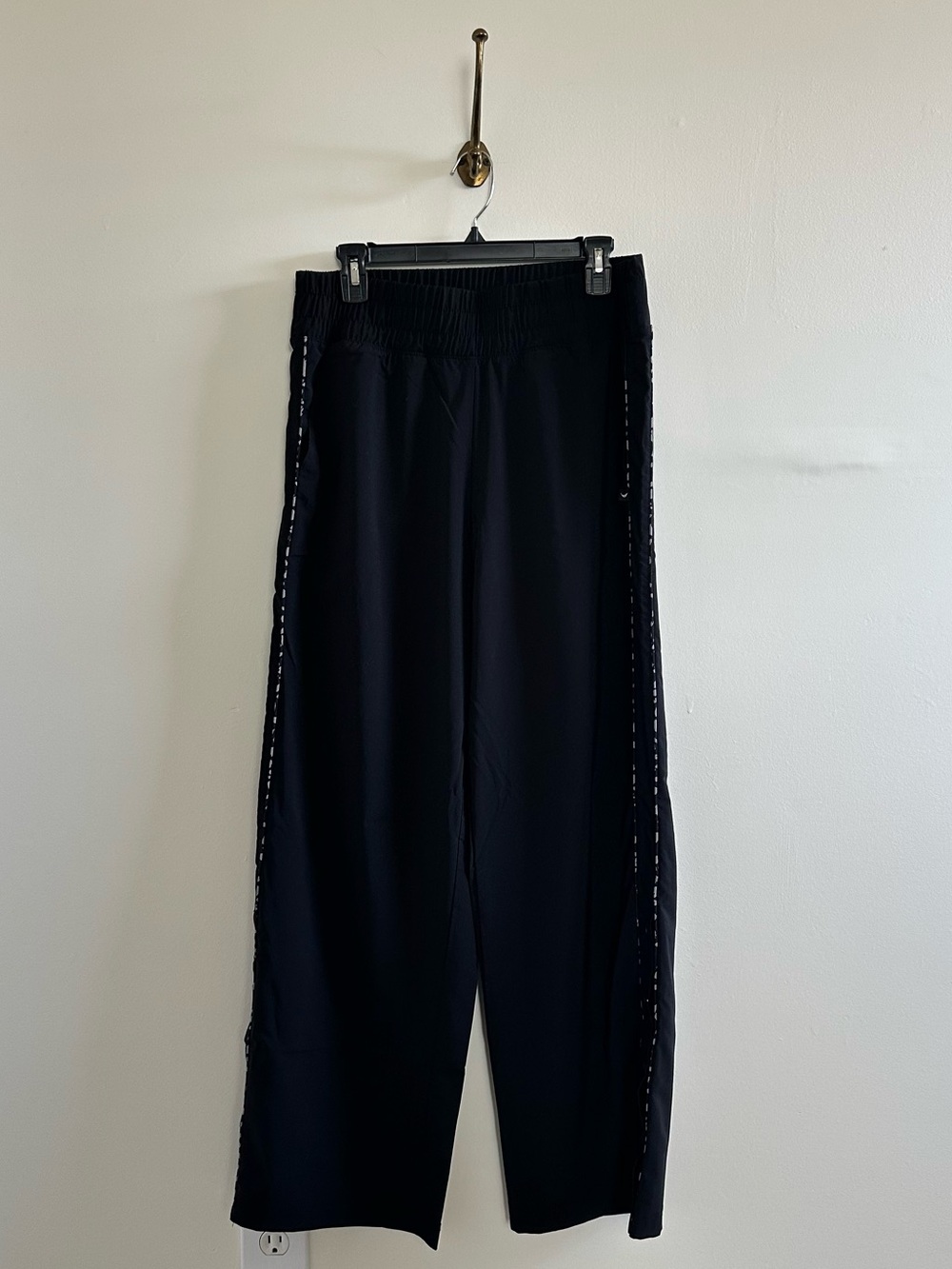 Black track pants with a leopard like piping stripe and snap side closure- L